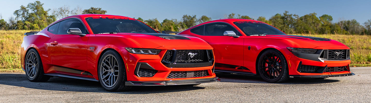 Ford Mustang Dark Horse and Mustang GT parked side by side, front three-quarter view