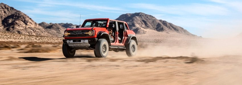 ford bronco raptor driving in sand